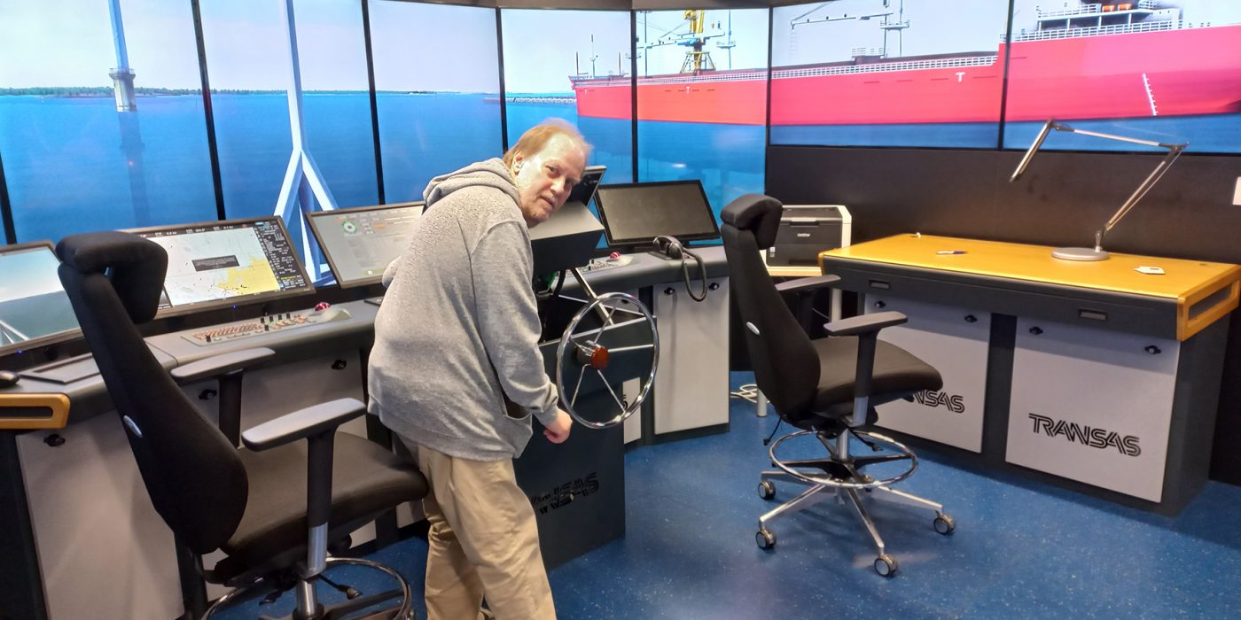 Jari Kumlander seisoo merenkulun simulaattorin komentosillalla.