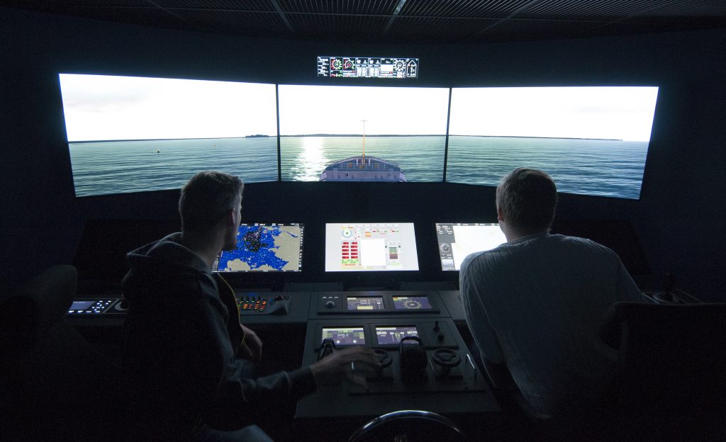 Two people working at a maritime simulator.