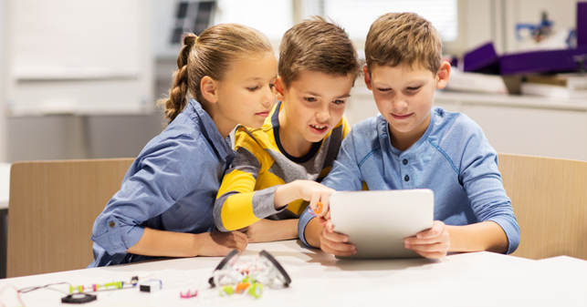 Children reading a paper together.