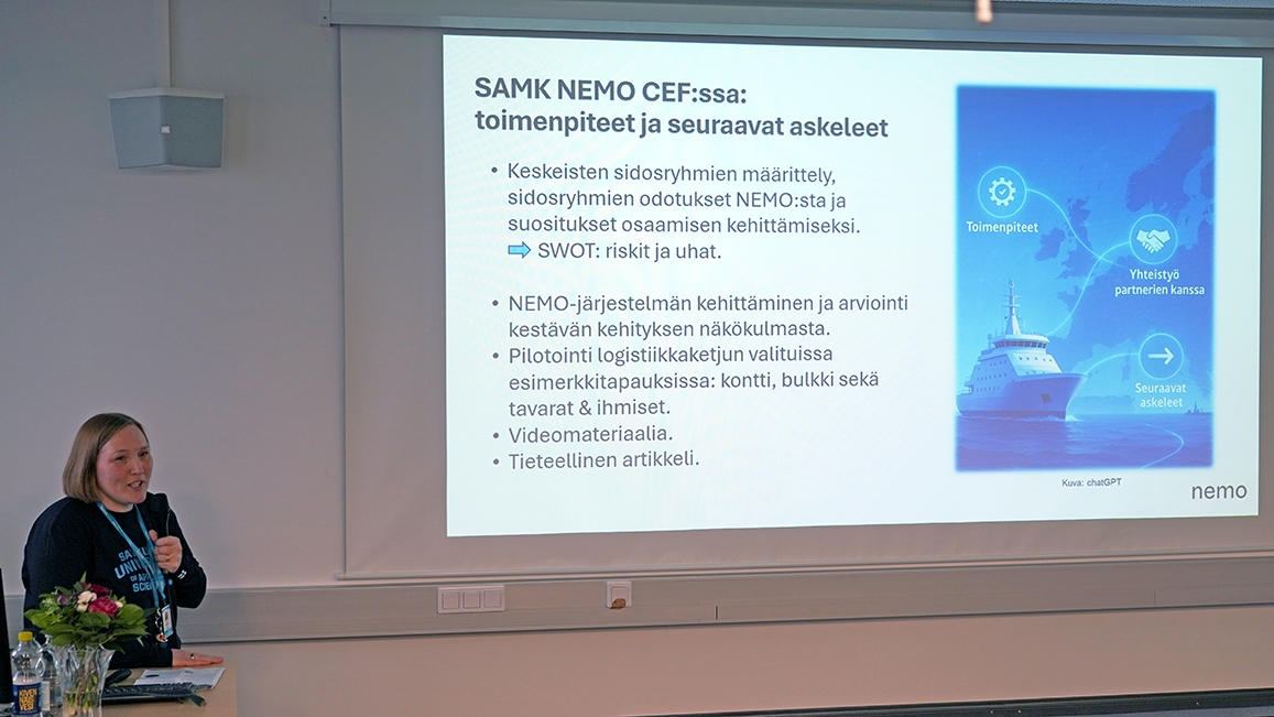 Kati Renholm auditorion edessä pitämässä puhe-esitystä.