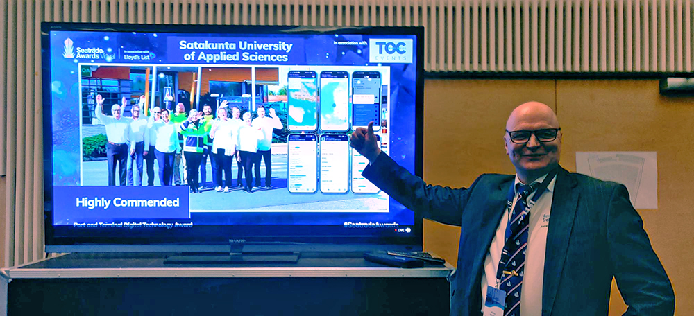Heikki Koivisto pointing at a screen showing the Seatrade Awards “Highly Commended” recognition.