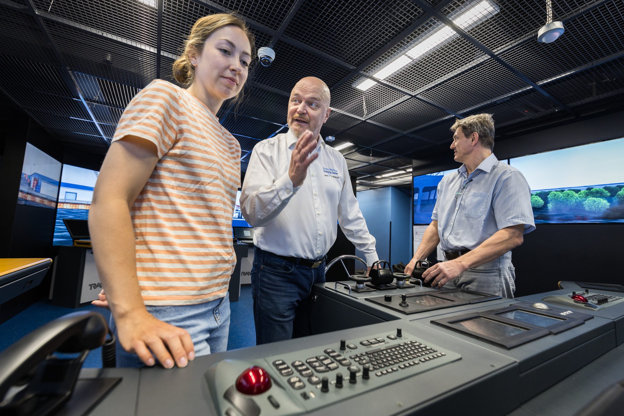 Three people in a bridge simulator.