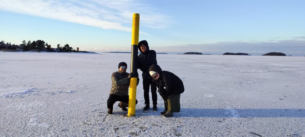 Koki Matsushima, Shohei Goto, Asami Shimada pose by a sea mark.