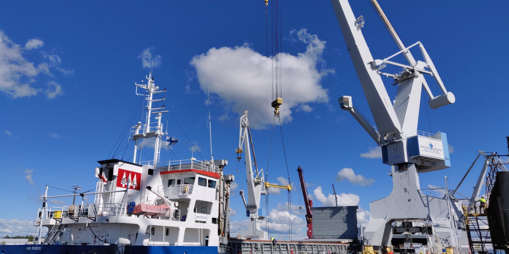The crane unloads the ship in port.