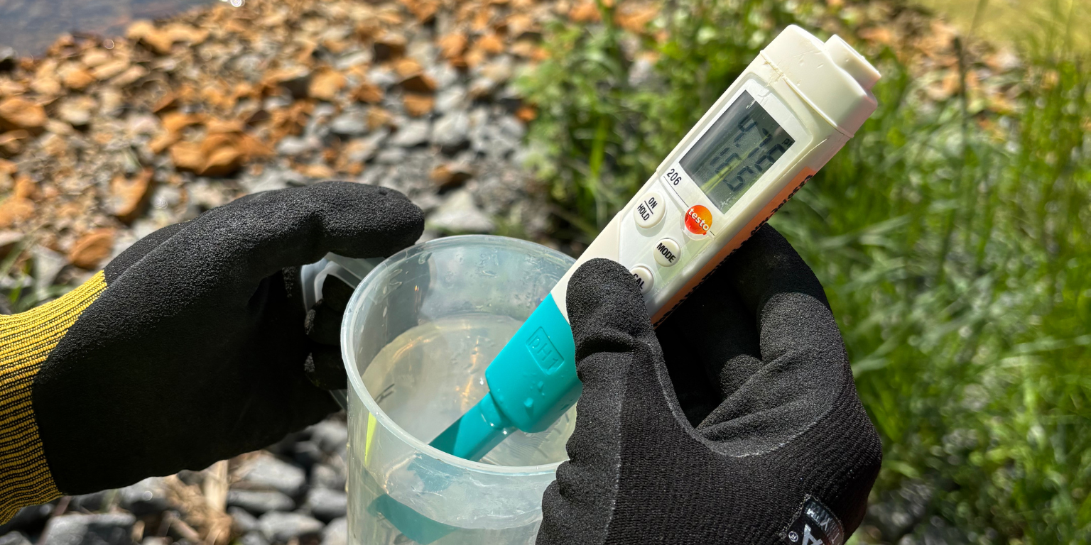 PH meter in water plants. Wetland in the background.