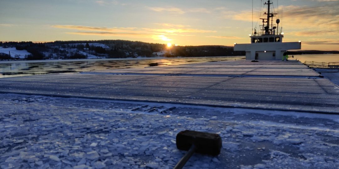 Lähikuva rahtilaivan kannelta. Kansi jäässä. Etualalla moukari, jolla jäätä rikotaan.