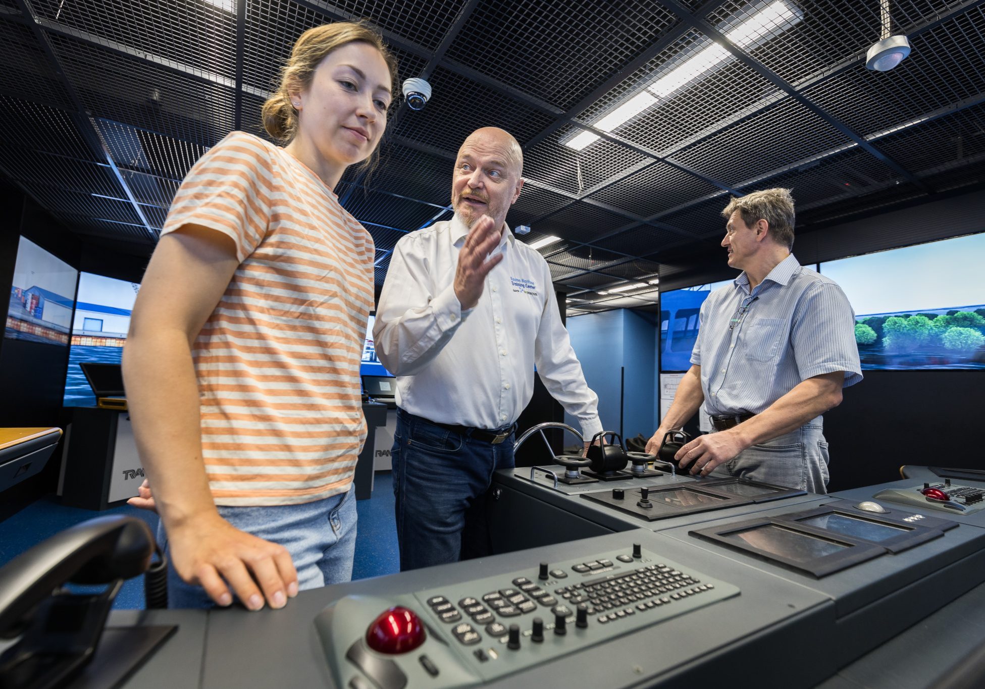 Kolme henkilöä kansisimulaattorissa.