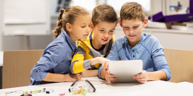 Children reading a paper together.